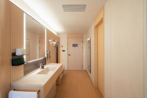 a bathroom with a sink and a mirror at JI Hotel Qingdao Haier Industrial Park Wannianquan Road Subway Station in Qingdao +27 photos