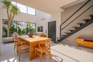 ein Esszimmer mit einem Holztisch und Stühlen in der Unterkunft Luxury 4BR Villa Private Pool & Sea Horizon in Kerobokan