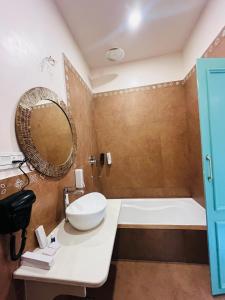 a bathroom with a tub and a sink and a mirror at Artistik Abode in Varanasi +31 photos