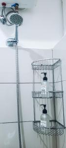 a bathroom with a shower with three shelves on the wall at Modern Apartment - Work from Zanzibar (Fumba Town) in Dambani