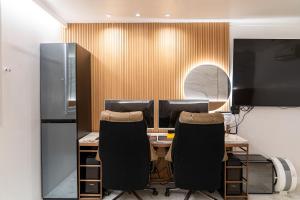 an office with two chairs and a desk with two monitors at S Hotel in Bucheon