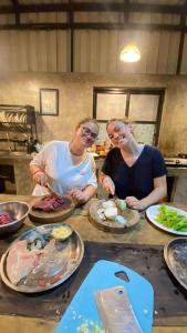 two women standing in a kitchen preparing food at Battambang Eco Stay &cooking class in Battambang