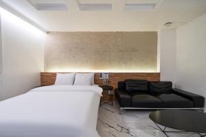 a hotel room with a bed and a couch at S Hotel in Bucheon