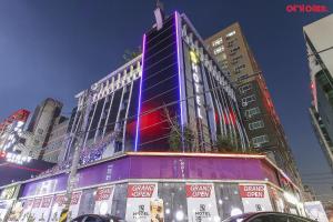 a tall building with a purple in a city at S Hotel in Bucheon