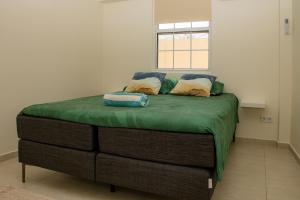 a bed with two pillows on it in a room at WaraWara Mini resort in Jan Thiel +69 photos