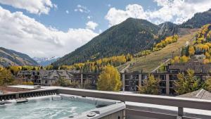 bañera de hidromasaje en la azotea de un edificio con montañas en Center of Aspen Studio with AC Sundeck & Hot-Tub, en Aspen