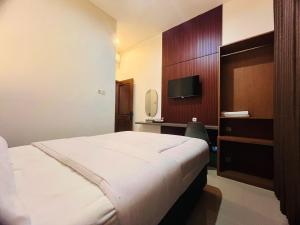 a hotel room with a bed and a television at Hause of Bejo Yogyakarta in Demangan +10 photos