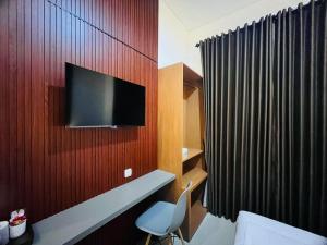 a room with a tv on a wooden wall at Hause of Bejo Yogyakarta in Demangan