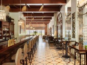 a restaurant with a long bar with chairs and tables at Fairmont Makati in Manila