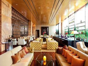 un restaurante con sofás y un bar con gente dentro en Fairmont Beijing - 20 minutes to Forbidden City by metro, en Beijing