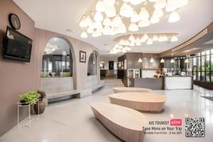 een lobby met twee tafels en een grote kroonluchter bij I Pavilion Hotel Phuket in Phuket