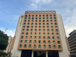 a tall building with a sign on the front of it at Flat Comfort Taguatinga - Cama King - Sauna, academia e Piscina - Propriedade Particular 508 in Brasilia