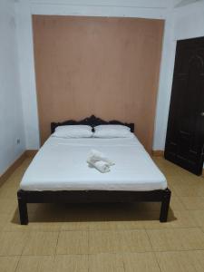 a bed with two white towels on top of it at Touristlink Homestay in Donsol +10 photos
