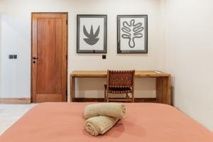 ein Schlafzimmer mit einem Bett, einem Schreibtisch und einem Stuhl in der Unterkunft Stylish New Suites with Pool Near Balangan Beach in Bingin Beach + 15 Fotos