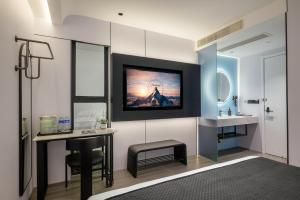 a bathroom with a desk and a tv on the wall at The Panda Artisan, Taikoo Li Xilia Hotel in Chengdu