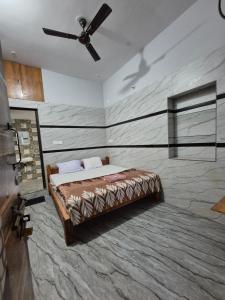 ein Schlafzimmer mit einem Bett und einem Deckenventilator in der Unterkunft Khushi's Paradise Villa hampi in Hampi