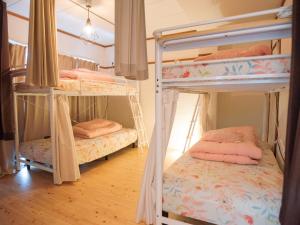 two bunk beds in a room with wooden floors at Guesthouse Banvina in Kagoshima