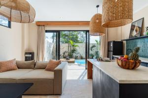 eine Küche und ein Wohnzimmer mit einer Couch und einem Tisch in der Unterkunft Tranquil Oasis Pool, Seamless WiFi and Workspace in Bingin Beach