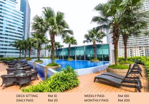 a resort with a swimming pool and palm trees at KLCC View Penthouse in Kuala Lumpur