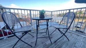 a table and two chairs on a balcony at Quiet Central Dunedin Apartment & covered parking in Dunedin