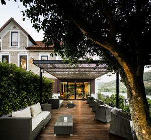 an outdoor patio with couches and a tree at Quinta de S.Bernardo - Winery & Farmhouse in Mesão Frio