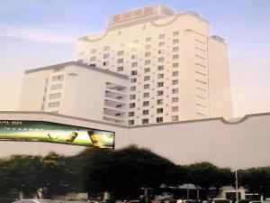 ein großes weißes Gebäude mit einer Plakatwand davor in der Unterkunft Fujian Galaxy Garden Hotel in Fuzhou