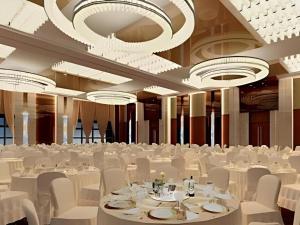 a banquet hall with white tables and chairs and chandeliers at Wuhan Tieqiao Jianguo Hotel in Wuhan