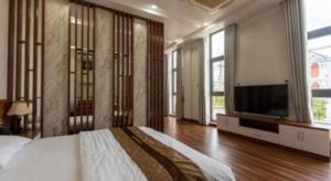 a bedroom with a large bed and a flat screen tv at Hoang Hung Hotel in Hanoi