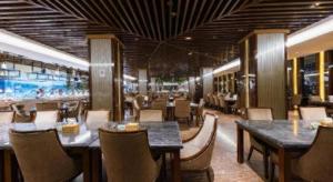 Un restaurante con mesas y sillas y una piscina. en Qingdao Haidu Hotel, en Huangdao