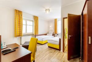 a hotel room with two beds and a desk at Altstadt-Hotel in Amberg