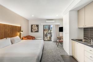 Una habitación de hotel con una cama grande y una cocina. en Adina Apartment Hotel Perth Barrack Plaza, en Perth 20 fotos más