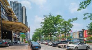 rząd samochodów zaparkowanych na ulicy miejskiej w obiekcie Oriental Glory Hotel w mieście Dongguan