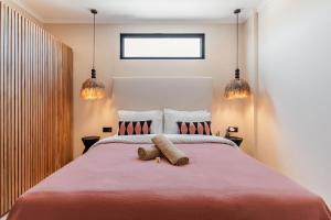 ein Schlafzimmer mit einem großen Bett mit zwei Kissen in der Unterkunft Brand-New Suites with Pool Minutes from Beach in Bingin Beach + 22 Fotos