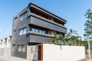 ein schwarzes Gebäude mit Bäumen davor in der Unterkunft Brand-New Suites with Pool Minutes from Beach in Bingin Beach