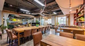 Un comedor con mesas y sillas de madera. en Xian Song Of Apple Hot Spring Hotel, en Xi'an