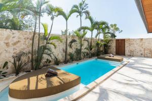 einen Pool im Hinterhof mit Palmen in der Unterkunft Brand-New Suites with Pool Minutes from Beach in Bingin Beach