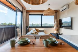 ein Wohnzimmer mit Tisch und Couch in der Unterkunft Brand-New Suites with Pool Minutes from Beach in Bingin Beach