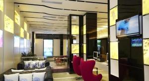 a living room with red chairs and a flat screen tv at Lavande Hotel Xian Xiaozhai Subway Station Dayanta Branch in Xi'an