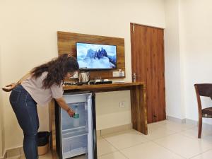 una mujer está mirando dentro de un refrigerador abierto en Hotel Ramayan Inn, en Rishīkesh 17 fotos más