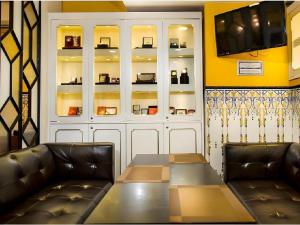 - une salle à manger avec 2 fauteuils en cuir et une table dans l'établissement Happy Family Hotel, à Macao