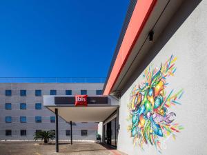 a building with a painting on the side of it at ibis Cuiaba Shopping in Cuiabá