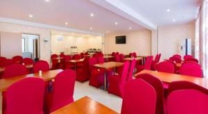 una sala de conferencias con sillas rojas, escritorios y mesas en IU Hotel Changsha Railway Station Branch, en Changsha