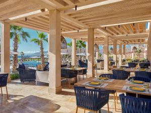 un patio dans un restaurant avec des tables et des chaises dans l'établissement Fairmont Taghazout Bay, à Taghazout