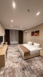 a large bedroom with a large bed and a desk at SUVON Hotel in Stantsiya Kyzyl-Tukumachi