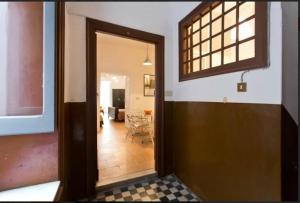 une porte ouverte menant à un salon avec une table dans l'établissement Casetta in centro, à Palerme