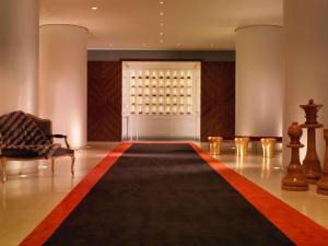 a large room with a rug and a window with wine bottles at St Martins Lane London in London