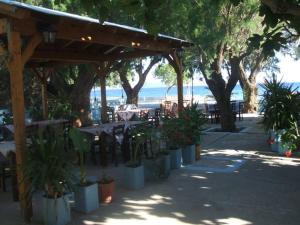 a patio with a table and chairs and trees at Pension Balos in Koumeika