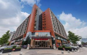 a tall building with cars parked in front of it at James Joyce Coffetel·Beijing Yizhuang Development Zone Dazu Square Tongji Road in Beijing