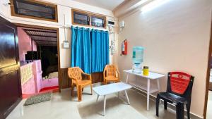 a living room with chairs and a table and a table at Royal Palace in Dibrugarh