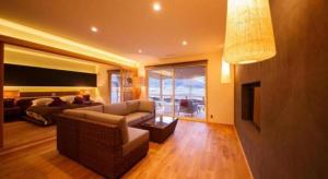 a living room with a couch and a tv and a living room at Yufuin Luxury Villa -zakuro- in Yufuin